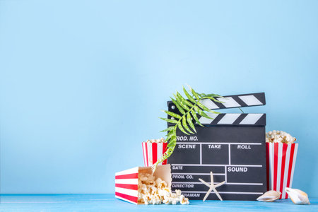 Summer holiday and vacation movie cinema marathon background Cinema clapper-board with sunglasses, seashells, starfish, popcorn buckets, vacation accessories, Cinema for the summer Movie Night partyの写真素材