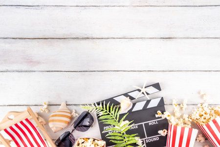 Summer holiday and vacation movie cinema marathon background Cinema clapper-board with sunglasses, seashells, starfish, popcorn buckets, vacation accessories, Cinema for the summer Movie Night partyの写真素材