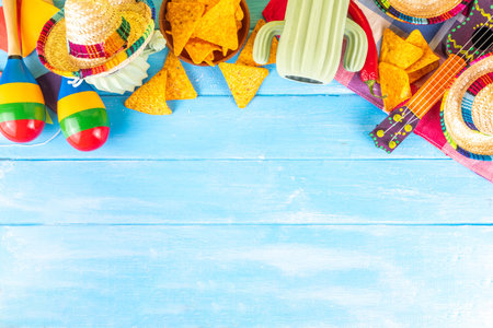 Cinco de Mayo holiday background with Mexican cactus decor, party sombrero hat, nachos chips, guitar, maracas. Cinco de Mayo holiday celebration greeting card, copy spaceの写真素材