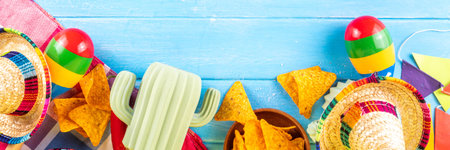 Cinco de Mayo holiday background with Mexican cactus decor, party sombrero hat, nachos chips, guitar, maracas. Cinco de Mayo holiday celebration greeting card, copy spaceの写真素材