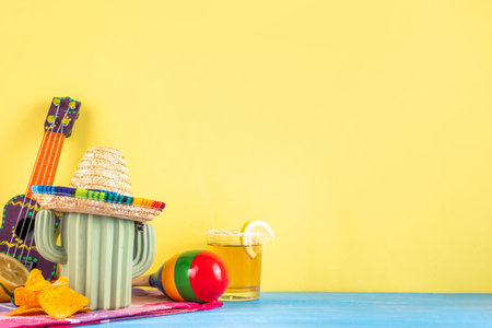 Cinco de Mayo holiday background with Mexican cactus decor, party sombrero hat, nachos chips, guitar, maracas. Cinco de Mayo holiday celebration greeting card, copy spaceの写真素材