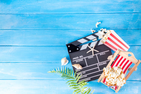Summer holiday and vacation movie cinema marathon background Cinema clapper-board with sunglasses, seashells, starfish, popcorn buckets, vacation accessories, Cinema for the summer Movie Night partyの写真素材