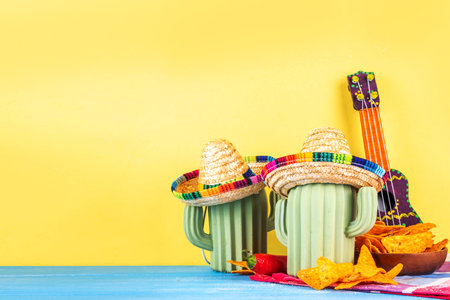 Cinco de Mayo holiday background with Mexican cactus decor, party sombrero hat, nachos chips, guitar, maracas. Cinco de Mayo holiday celebration greeting card, copy spaceの写真素材