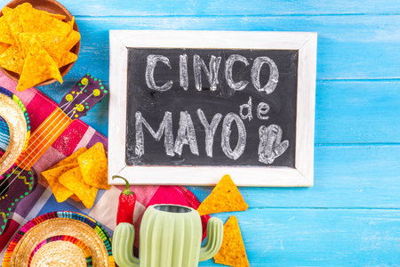 Cinco de Mayo holiday background with Mexican cactus decor, party sombrero hat, nachos chips, guitar, maracas. Cinco de Mayo holiday celebration greeting card, copy spaceの写真素材