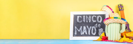 Cinco de Mayo holiday background with Mexican cactus decor, party sombrero hat, nachos chips, guitar, maracas. Cinco de Mayo holiday celebration greeting card, copy spaceの写真素材