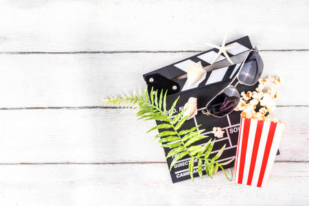 Summer holiday and vacation movie cinema marathon background Cinema clapper-board with sunglasses, seashells, starfish, popcorn buckets, vacation accessories, Cinema for the summer Movie Night partyの写真素材