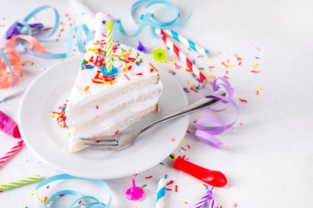 Birthday cake slice on birthday party decorated table.  Slice of Birthday Cake with white whipped cream, sugar sprinkles funfetti and candle, copy spaceの写真素材