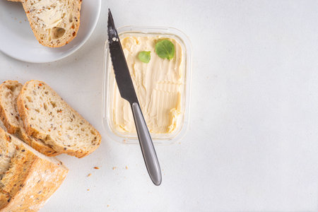 Homemade Vegan Butter, non-dairy creamy, plant based alternative butter with soy bean, and home baked bread on kitchen white table backgroundの写真素材