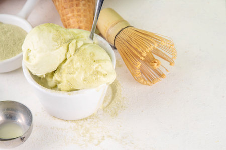 Matcha ice cream. Bowl with matcha green tea taste gellato with ice cream waffle cones. Vegan non-dairy summer dessert with matcha latte powder on topの写真素材
