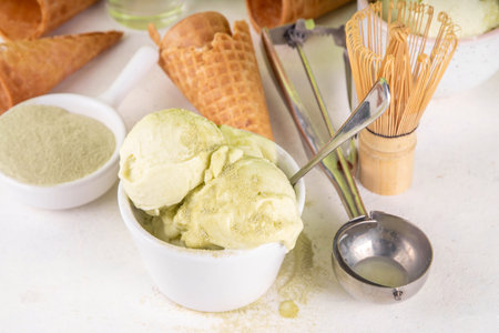 Matcha ice cream. Bowl with matcha green tea taste gellato with ice cream waffle cones. Vegan non-dairy summer dessert with matcha latte powder on topの写真素材