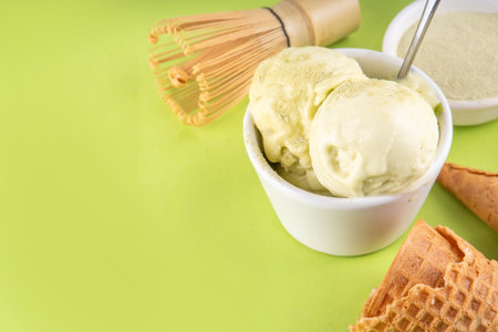 Matcha ice cream. Bowl with matcha green tea taste gellato with ice cream waffle cones. Vegan non-dairy summer dessert with matcha latte powder on topの写真素材
