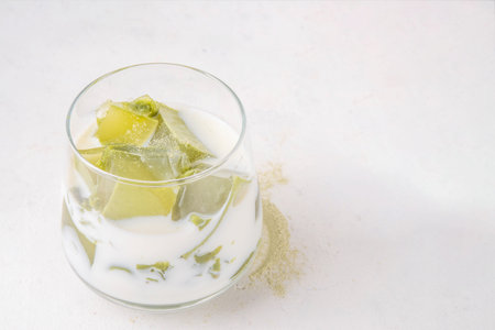 Matcha jelly latte, iced milky drink with green matcha tea jellatin cubes, trendy refreshing Iced non-caffeine healthy drinkの写真素材