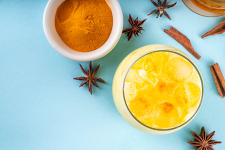 Iced golden milk drink, turmeric latte with ice cubes, Tasty summer cold beverage, alternative ayurvedic cocktailの写真素材
