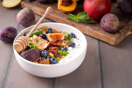 Healthy autumn breakfast bowl. Cottage cheese or yogurt with granola, nuts and fall seasonal fruits,balanced comfort food snack for morning and lunch, copy spaceの写真素材