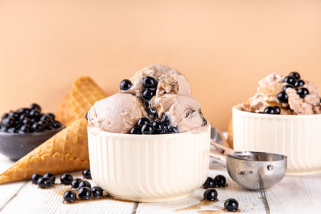 Bubble milk tea ice cream, sweet taiwanese asian style milky tea with Kuromitsu, black boba or tapioca pearls and syrup, in portioned bowls with ice cream cones, white wooden table copy spaceの写真素材