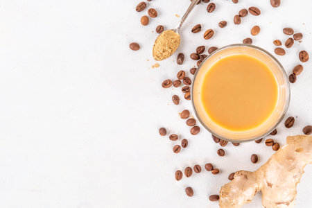 Fresh brewed ginger coffee latte cup. Creamy hot drink with ginger powder and ginger root, on white background. Healthy hot beverage. alternative medicine, remedyの写真素材