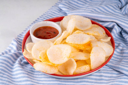 Crispy airy rice shrimp chips. Fragrant prawn crackers with sauce, traditional Asian fast food snack, junk food healthier alternativeの写真素材