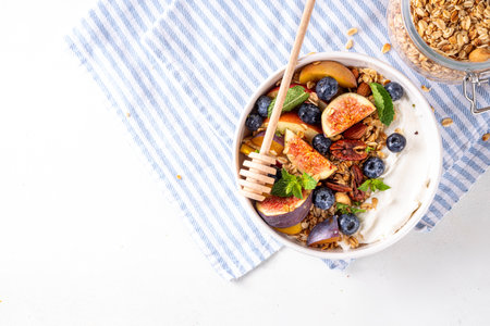 Healthy autumn breakfast bowl. Cottage cheese or yogurt with granola, nuts and fall seasonal fruits,balanced comfort food snack for morning and lunch, copy spaceの写真素材