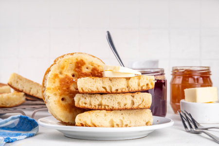 Traditional English skillet fried breakfast pastry Crumpets, popular in England, Britain pancakes. Sweet hot crumpets stack with melting butter and jamの写真素材