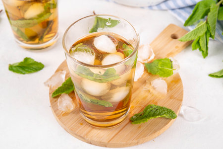 Mint and honey iced tea drink, cold summer refreshment cold beverage with a lot of mint leaves, honey and iced cubes, copy spaceの写真素材