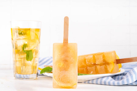 Iced tea or lemonade popsicles, sweet lemon and mint cocktail lollies with cold drink, lemon slices and mint leaves copy spaceの写真素材