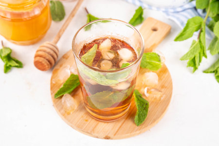 Mint and honey iced tea drink, cold summer refreshment cold beverage with a lot of mint leaves, honey and iced cubes, copy spaceの写真素材