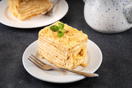 Homemade Napoleon cake slices, layered mille-feuille cake with vanilla creamy custard, tasty delicious puff pastry, on serving plates with forks, copy spaceの写真素材