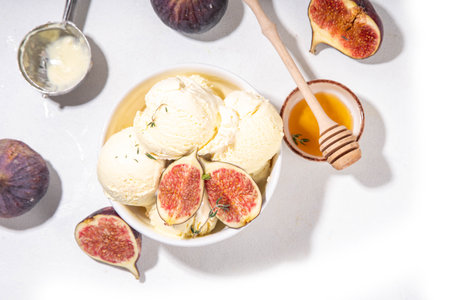 Tasty fig gelato ice cream, aromatic and creamy fruit sorbet dessert with autumn spicy flavour, in portioned bowl, on wooden cozy background with whole and slices figs, copy spaceの写真素材