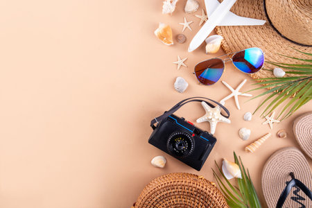 Summer holiday and vacation background with straw hat, bag, flip flops, palm leaves, sunglasses, camera, seashells and ocean starfish. Beach and tropical summer vacation background, top view copy spaceの写真素材