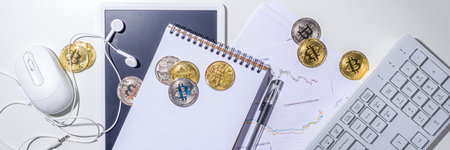 Bitcoin coins on office  desktop workspace. Working with cryptocurrency markets concept. Keyboard,...