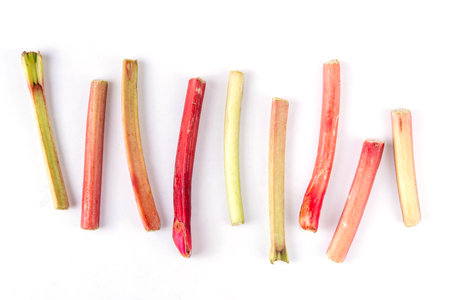 Raw fresh organic rhubarb stems on white background, bunch of homegrown pink and green rhubarb ready for cooking dish, dessert or jam. Summer harvest, cooking ingredientの写真素材