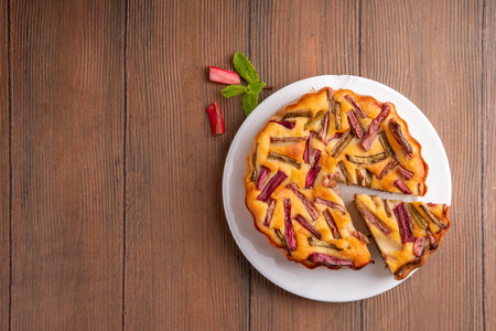 Summer homemade baking, tasty rhubarb pie. Sweet seasonal dessert recipe, sponge cake with rhubarb slices on top and sweet jam insideの写真素材