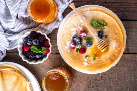 Traditional Maslenitsa food, Eastern European Slavic thin pancakes crepes, with various sweet spreads, toppings and fillings - honey, berries, jamsの写真素材