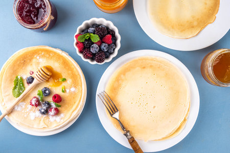 Traditional Maslenitsa food, Eastern European Slavic thin pancakes crepes, with various sweet spreads, toppings and fillings - honey, berries, jamsの写真素材