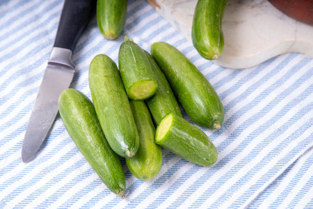 Tasty raw organic mini baby cucumbers, micro one bite cucumbers, for finger food and sandwiches, on white table background copy spaceの写真素材