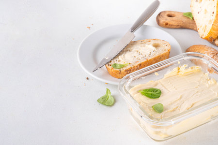 Homemade Vegan Butter, non-dairy creamy, plant based alternative butter with soy bean leave, and home baked bread on kitchen white table backgroundの写真素材