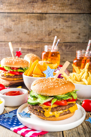 Celebrating Independence Day, July 4. Traditional American Memorial Day Patriotic Picnic with burgers, French fries and snacks, Summer USA picnic and bbq concept, Old wooden backgroundの写真素材