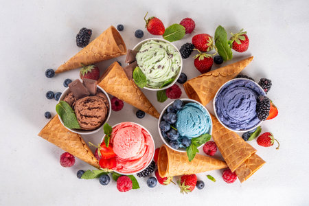 Colorful bright ice cream on bowls, with waffle cones and berries, on white background. Variety of ice cream portions with different flavor with fresh berries top view copy space layout backgroundの写真素材