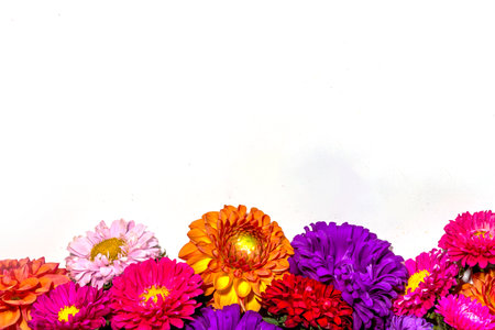 Autumn flowers flatlay background. Bouquet of colorful chrysanthemum, peonies (orange, purple, yellow, red) flowers on white background, frame border for greeting card top view copy space for textの写真素材