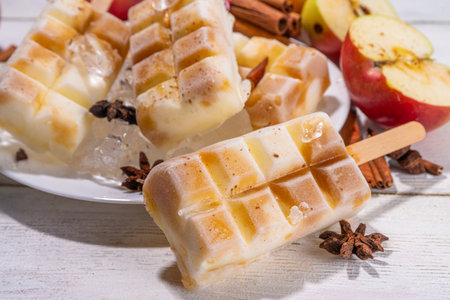 Apple pie ice cream popsicles on a stick. Homemade lollipops with apple pie spicy flavor, on wooden table backgroundの写真素材
