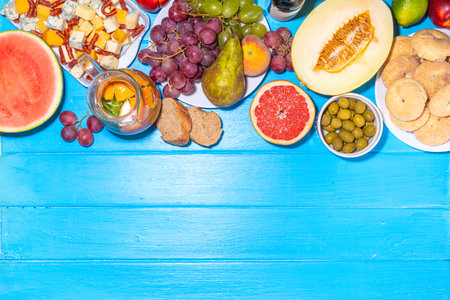 Buon Ferragosto (happy in italian language) holiday background. Summer Italian harvest festival August 15  brunch, family party antipasto foods with watermelon, melon, grapes, cheese, snacks, drinksの写真素材