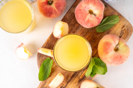 Flat peaches fig peach juice with fresh fig peaches and mint in white background copy spaceの写真素材