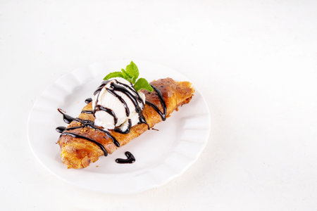 Trendy viral korean style flat croissant with ice cream and chocolate sauce, sweet sugared caramel glazed croissant for breakfast, copy spaceの写真素材