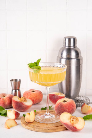 Flat peach martini or margarita lemonade cold fruit drink, summer iced fruit juice cocktail with mint and lemon, on white tableの写真素材