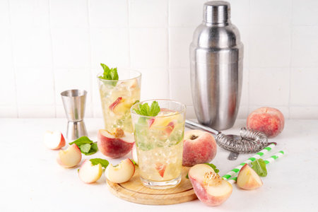 Flat peach lemonade, iced tea or mojito cocktail with fresh fruit garnish. Sweet non-alcohol flat peaches mocktail with peach slices, mint and crushes iceの写真素材