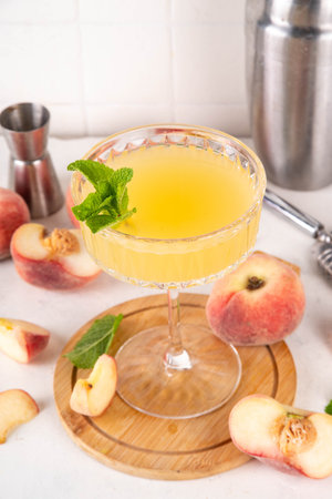 Flat peach martini or margarita lemonade cold fruit drink, summer iced fruit juice cocktail with mint and lemon, on white tableの写真素材
