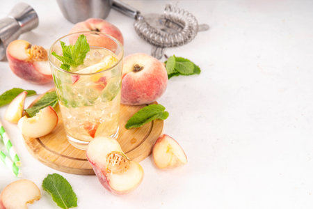 Flat peach lemonade, iced tea or mojito cocktail with fresh fruit garnish. Sweet non-alcohol flat peaches fig peach mocktail with peach slices, mint and crushes iceの写真素材