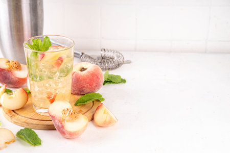 Flat peach lemonade, iced tea or mojito cocktail with fresh fruit garnish. Sweet non-alcohol flat peaches fig peach mocktail with peach slices, mint and crushes iceの写真素材