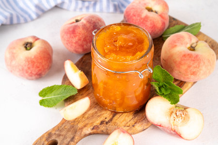 Flat chinese peaches fig peach jam, homemade confiture preserves with fresh fresh fig peaches and mint in white background copy spaceの写真素材