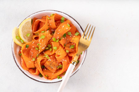 Viral trendy asian carrot salad with apple or wine vinegar, a little oil and salt, also known as Carrot Ribbon Salad. Trending carrot salad recipe, source of beta-carotene, healthy diet foodの写真素材
